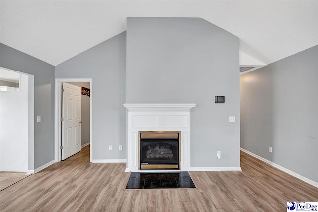 unfurnished living room featuring lofted ceiling and light hardwood / wood-style floors