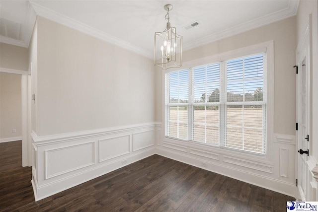 empty room featuring dark hardwood / wood-style flooring, a notable chandelier, and crown molding