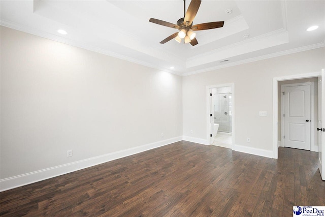 empty room with crown molding, dark wood-type flooring, ceiling fan, and a tray ceiling