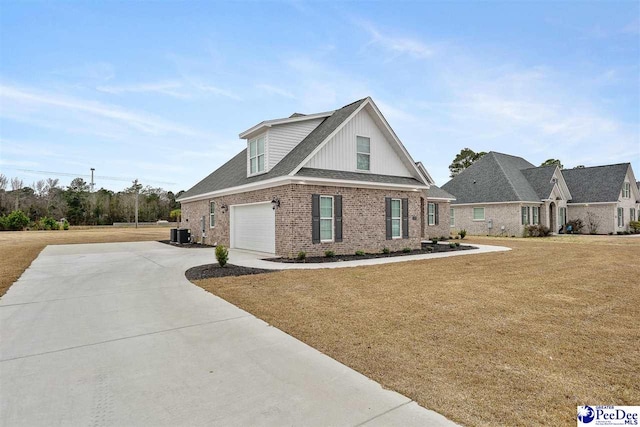 view of front facade with cooling unit, a garage, and a front lawn