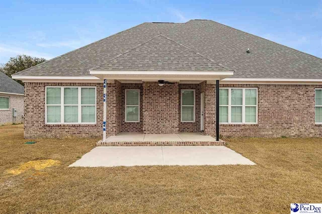 back of property with a yard and a patio area