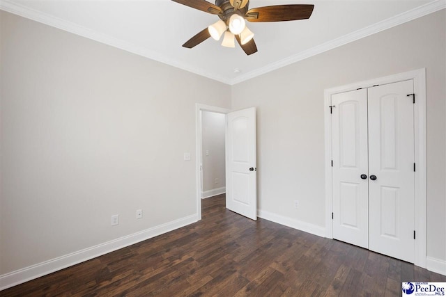 unfurnished bedroom featuring ceiling fan, ornamental molding, dark hardwood / wood-style floors, and a closet