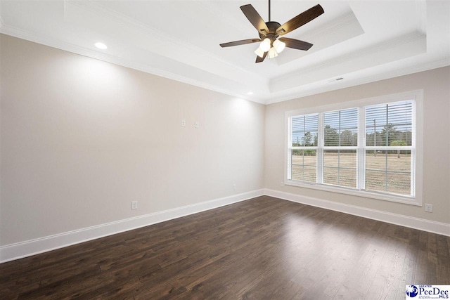 spare room featuring a tray ceiling, dark wood-type flooring, ornamental molding, and ceiling fan