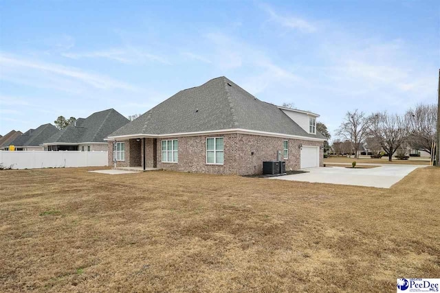 back of property with cooling unit, a yard, a patio area, and a garage