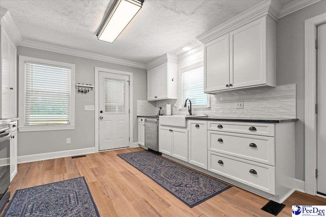 3900 Claussen Rd, Florence, SC 29505 - kitchen with stainless steel dishwasher, a textured ceiling, decorative backsplash, light wood-style floors, and dark countertops