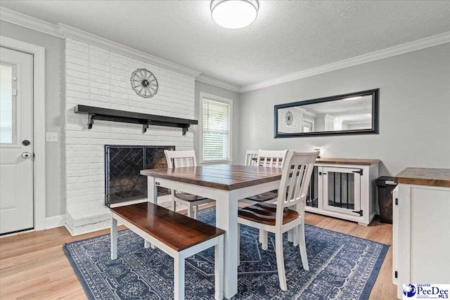 3900 Claussen Rd, Florence, SC 29505 - dining room featuring light wood-style flooring, a textured ceiling, ornamental molding, and a fireplace