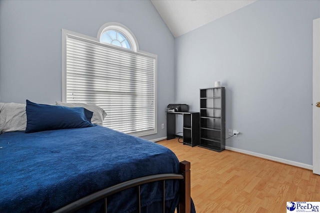 bedroom featuring hardwood / wood-style flooring and lofted ceiling