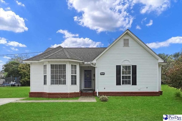 813 Williams St, Lake City, SC 29560 - view of front facade featuring a shingled roof, a front yard, and a trampoline