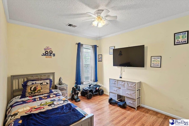 813 Williams St, Lake City, SC 29560 - bedroom featuring wood finished floors, crown molding, a textured ceiling, and visible vents
