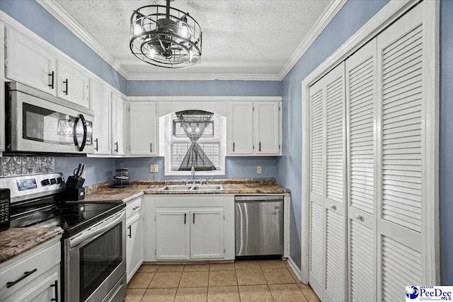 813 Williams St, Lake City, SC 29560 - kitchen with a notable chandelier, a sink, appliances with stainless steel finishes, white cabinets, and ornamental molding