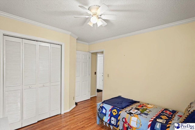 813 Williams St, Lake City, SC 29560 - bedroom featuring a closet, a textured ceiling, ornamental molding, ceiling fan, and light wood-type flooring