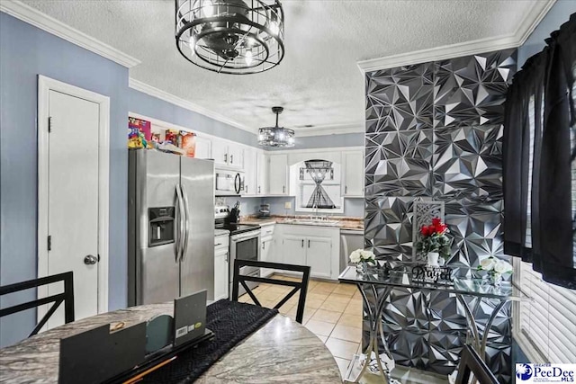 813 Williams St, Lake City, SC 29560 - kitchen with light tile patterned flooring, a chandelier, ornamental molding, stainless steel appliances, and white cabinetry