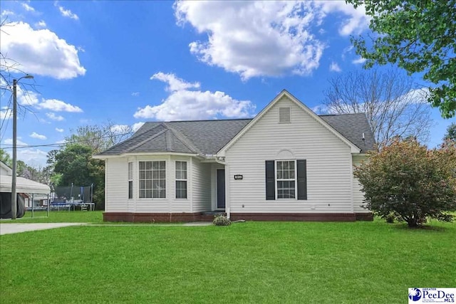 813 Williams St, Lake City, SC 29560 - view of front facade featuring a shingled roof, a front yard, and a trampoline