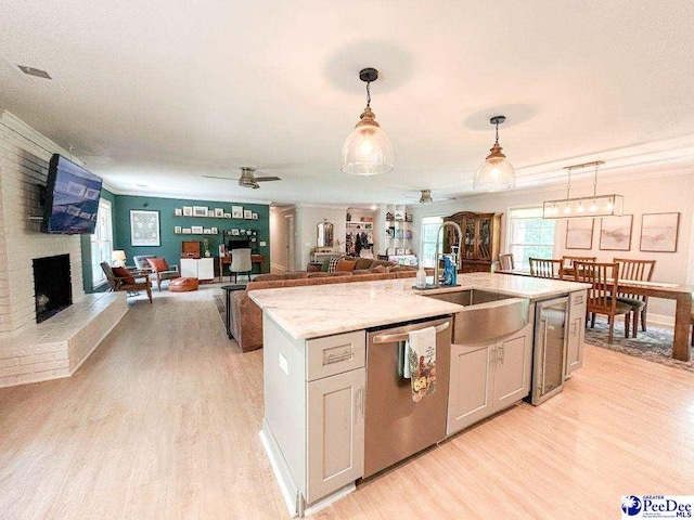 kitchen featuring dishwasher, light wood-style floors, a ceiling fan, decorative light fixtures, and ornamental molding