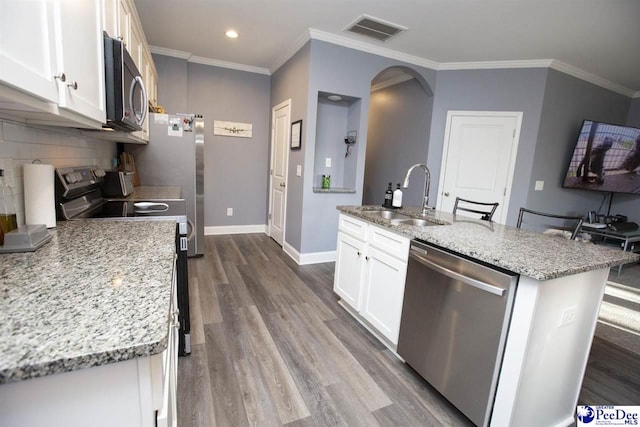 kitchen featuring sink, appliances with stainless steel finishes, white cabinetry, light stone countertops, and an island with sink