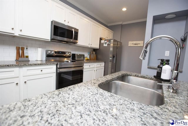 kitchen featuring appliances with stainless steel finishes, tasteful backsplash, sink, white cabinets, and light stone counters