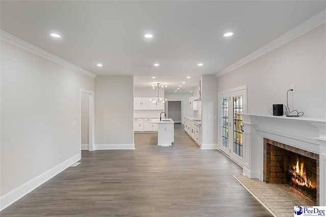400 Millstone Rd, Florence, SC 29505 - unfurnished living room featuring ornamental molding, a lit fireplace, wood finished floors, baseboards, and recessed lighting