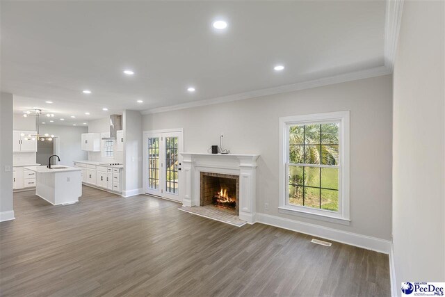 400 Millstone Rd, Florence, SC 29505 - unfurnished living room featuring a sink, a warm lit fireplace, ornamental molding, baseboards, and recessed lighting