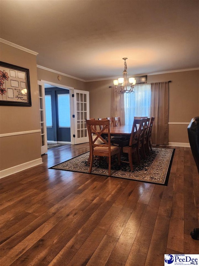 dining room featuring crown molding, dark hardwood / wood-style floors, and a notable chandelier