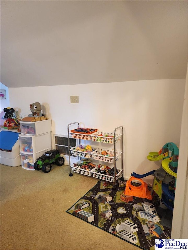 playroom with vaulted ceiling and carpet flooring