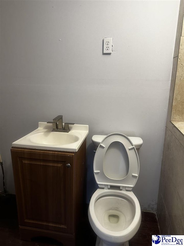 half bath featuring toilet and vanity