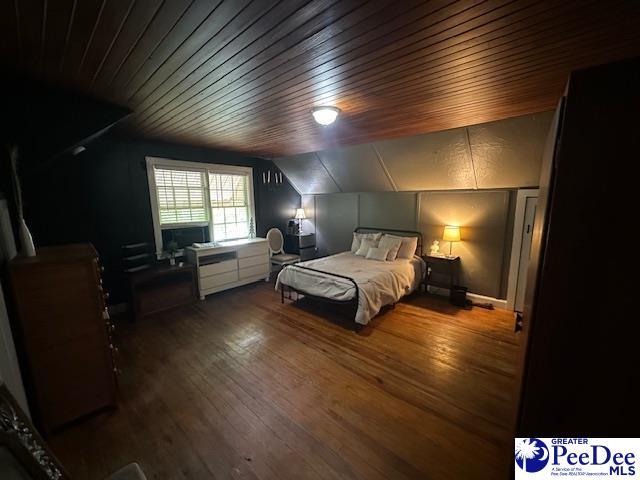 bedroom featuring lofted ceiling, wood-type flooring, and wooden ceiling