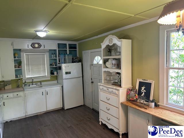 kitchen featuring open shelves, freestanding refrigerator, a sink, plenty of natural light, and crown molding