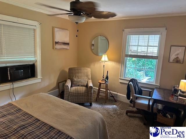 bedroom featuring carpet flooring, ornamental molding, cooling unit, baseboards, and ceiling fan