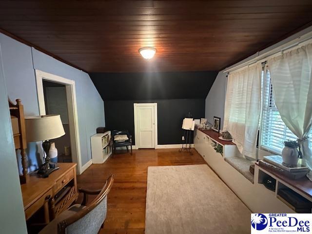living area featuring lofted ceiling, baseboards, wood finished floors, and wood ceiling
