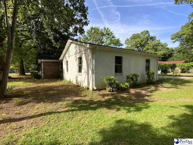 125 Forest Dr, Bennettsville, SC 29512 - view of side of property with a yard and stucco siding