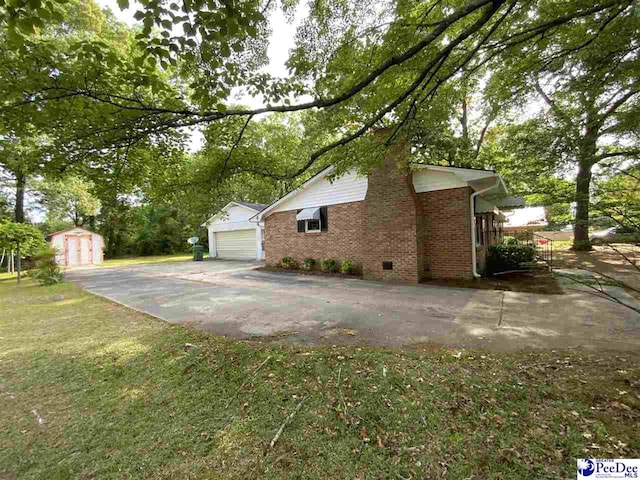 125 Forest Dr, Bennettsville, SC 29512 - view of side of home featuring brick siding, an outbuilding, a storage shed, a yard, and crawl space