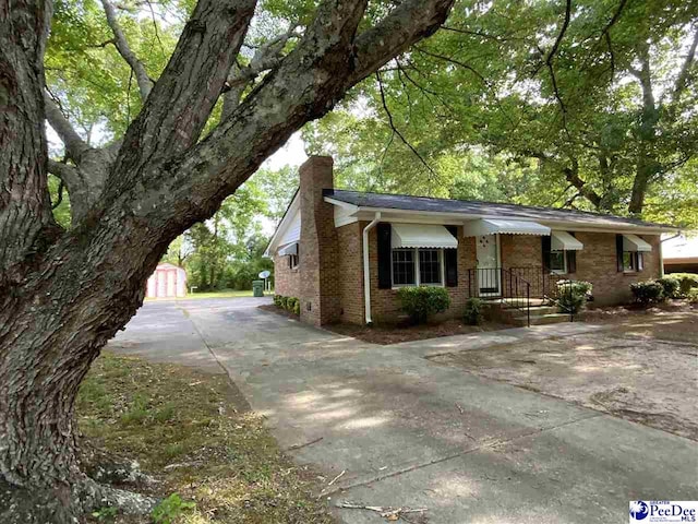 125 Forest Dr, Bennettsville, SC 29512 - view of side of property featuring a chimney, driveway, brick siding, and an outdoor structure