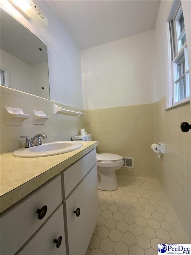 125 Forest Dr, Bennettsville, SC 29512 - bathroom with tile walls, tile patterned floors, vanity, toilet, and a wainscoted wall
