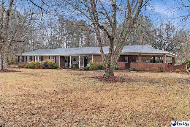 ranch-style house with a front lawn and covered porch