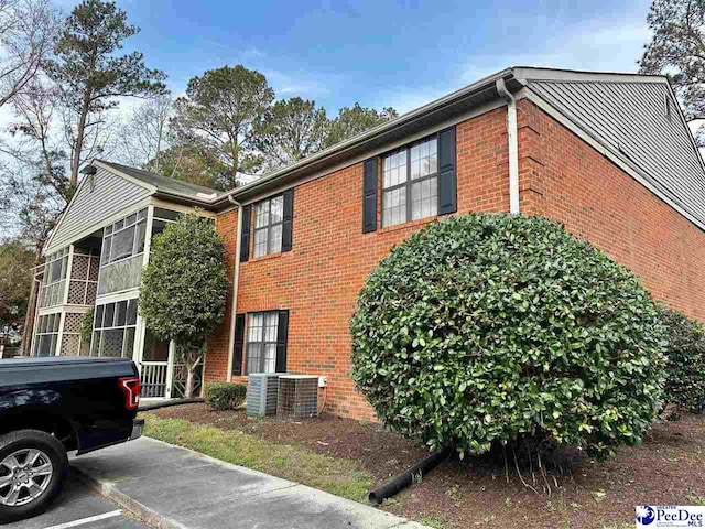 view of home's exterior with brick siding and central air condition unit