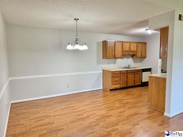 1215-G Brittany Dr, Florence, SC 29501 - kitchen with light wood-style flooring, brown cabinets, a sink, dishwashing machine, and a textured ceiling