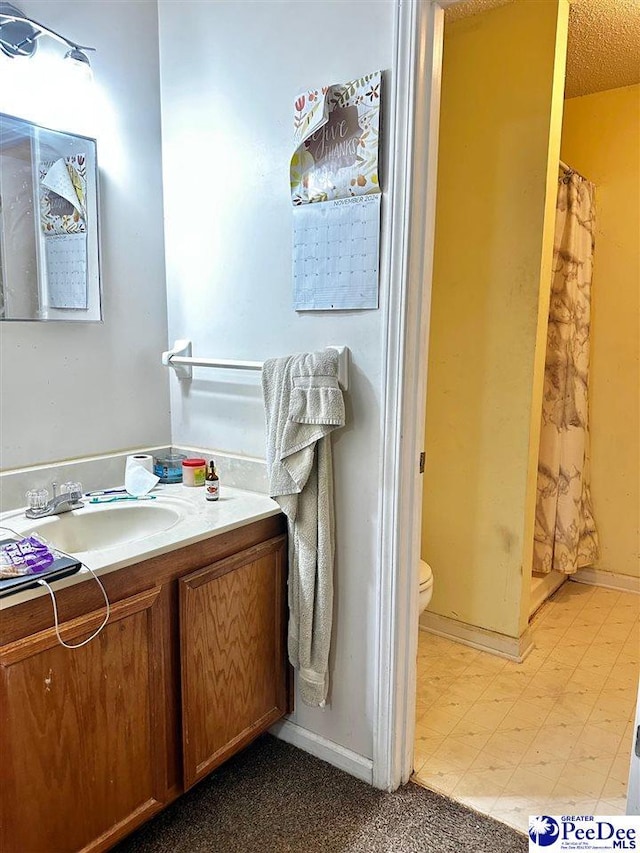 bathroom featuring toilet, vanity, tile patterned floors, and a shower with shower curtain