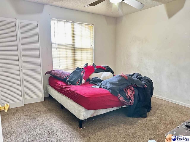 bedroom featuring baseboards, carpet flooring, a textured ceiling, and a ceiling fan
