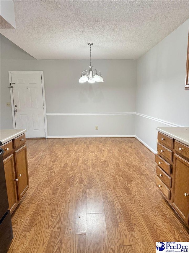 1215-G Brittany Dr, Florence, SC 29501 - unfurnished dining area featuring a chandelier, a textured ceiling, and light wood-style flooring
