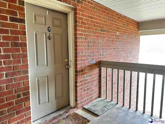 view of exterior entry with brick siding