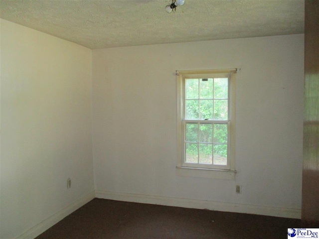 unfurnished room featuring a textured ceiling