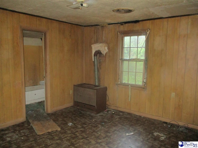 unfurnished living room featuring wooden walls