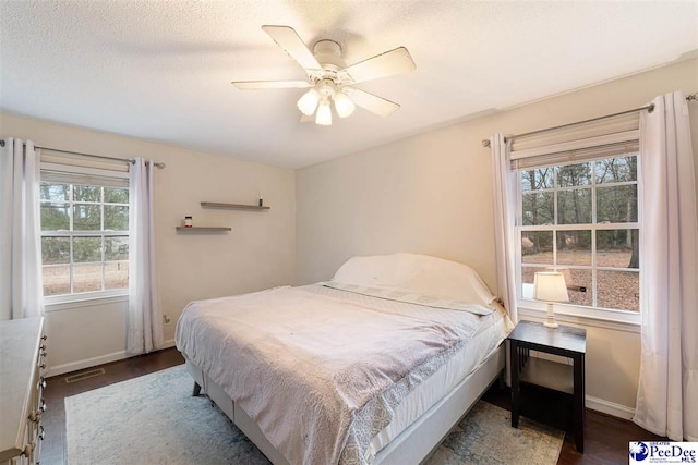 bedroom with ceiling fan and a textured ceiling