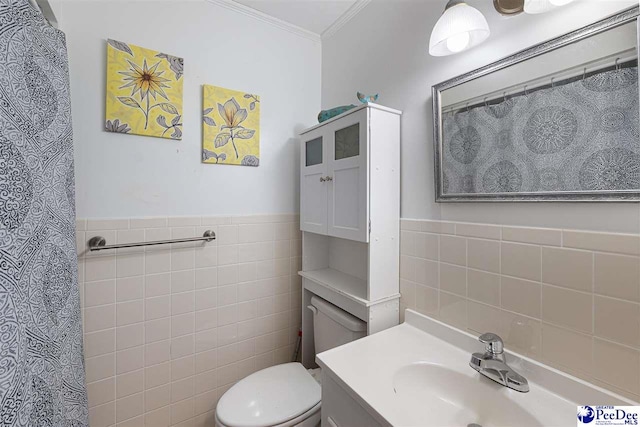 bathroom featuring ornamental molding, vanity, toilet, and tile walls