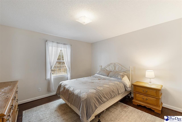 bedroom with dark wood-type flooring and a textured ceiling