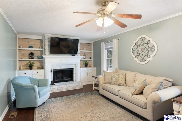 living room featuring a fireplace, hardwood / wood-style flooring, ornamental molding, ceiling fan, and a textured ceiling