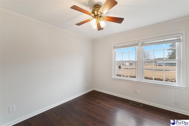 spare room featuring crown molding, ceiling fan, a healthy amount of sunlight, and dark hardwood / wood-style floors