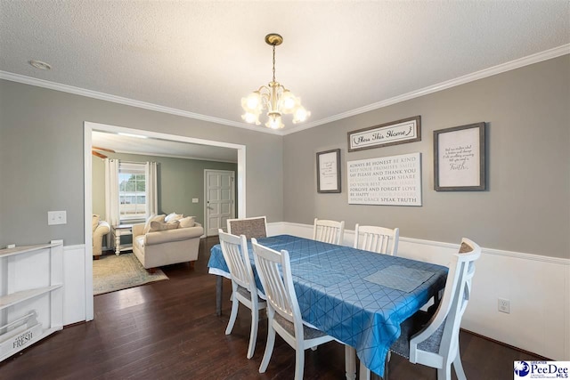 dining area with crown molding, dark wood-type flooring, a textured ceiling, and a chandelier