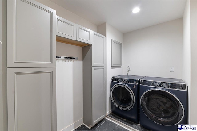 laundry room with cabinets, independent washer and dryer, and dark tile patterned floors