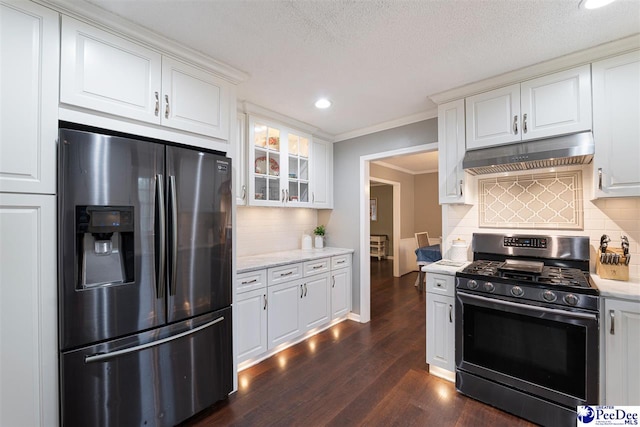 kitchen with dark wood-type flooring, tasteful backsplash, ornamental molding, appliances with stainless steel finishes, and white cabinets